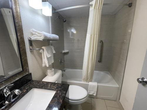 a bathroom with a toilet and a tub and a sink at Quality Inn & Suites Cincinnati Downtown Area in Cincinnati