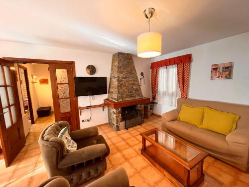 a living room with a couch and a fireplace at Cases Artigues in Os de Civís