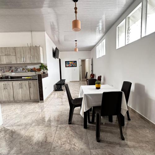 a dining room with a table and chairs and a kitchen at Apartamento Familiar Buga - Basílica señor de los milagros N1 in Buga