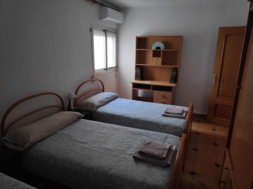 a bedroom with two beds and a window at Luna Home in Villajoyosa