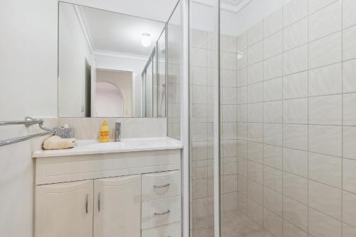 a white bathroom with a shower and a sink at NORM3/17 - Little Hacienda in Perth