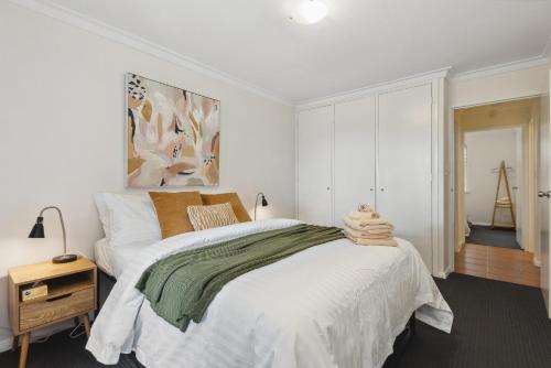 a white bedroom with a large bed and a table at NORM3/17 - Little Hacienda in Perth