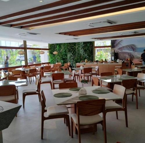 a dining room with tables and chairs in a restaurant at Flat Studio aconchegante com vista para piscina. in Ipojuca