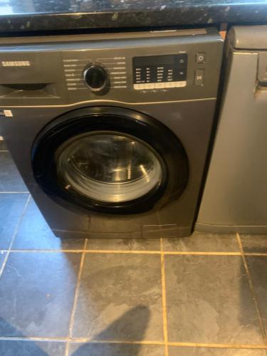 a washing machine with its door open in a kitchen at Celebrity Home in Woolwich