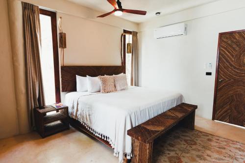 sypialnia z białym łóżkiem z drewnianym zagłówkiem w obiekcie Orchid House Tulum Beach w mieście Tulum