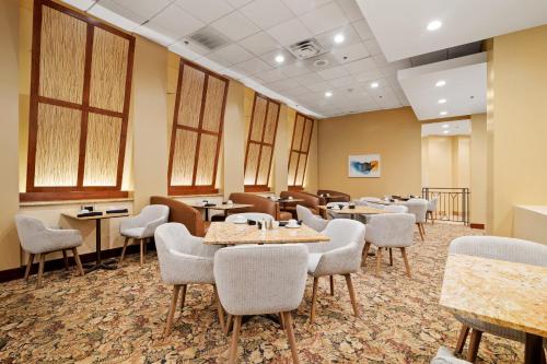 a waiting room with tables and chairs and windows at Crowne Plaza Houston Med Ctr-Galleria Area by IHG in Houston