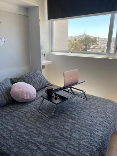 1 dormitorio con 1 cama y mesa con ordenador portátil en Departamento con piscina vista panorámica, en Coquimbo