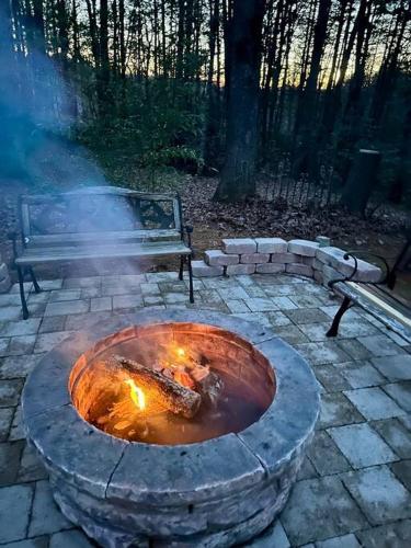 a fire pit with a bench next to a park at Beautiful & peaceful cabin w/ deck garden & fire-pit in Murphy