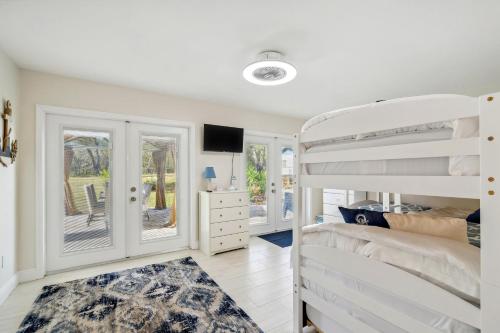 a bedroom with a white bunk bed and a tv at Bikes, Yard and Fire Pit at Upscale Lecanto Home! in Lecanto