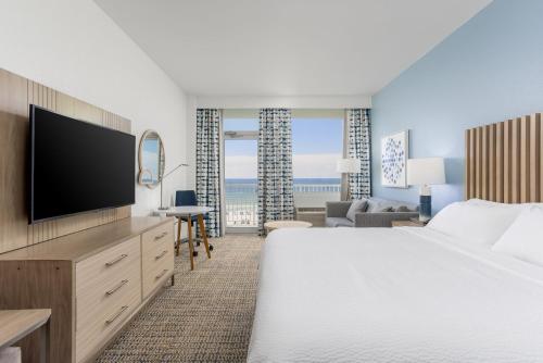 a hotel room with a bed and a flat screen tv at Holiday Inn Resort Pensacola Beach, an IHG Hotel in Pensacola Beach