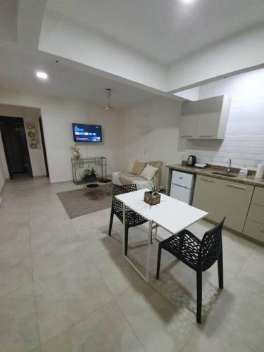 a kitchen and a living room with a table and chairs at Departamento Nuevo, Asunción in Asunción