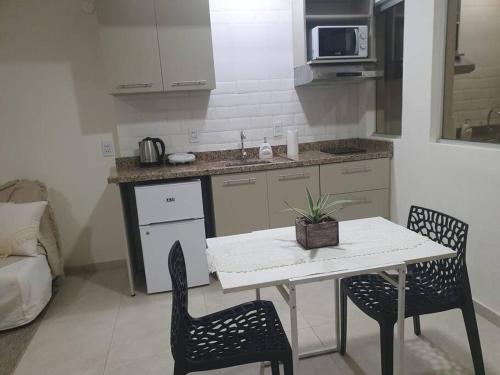 een keuken met een tafel en twee stoelen en een witte tafel bij Departamento Nuevo, Asunción in Asuncion