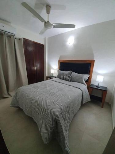 a bedroom with a bed and a ceiling fan at Departamento Nuevo, Asunción in Asunción