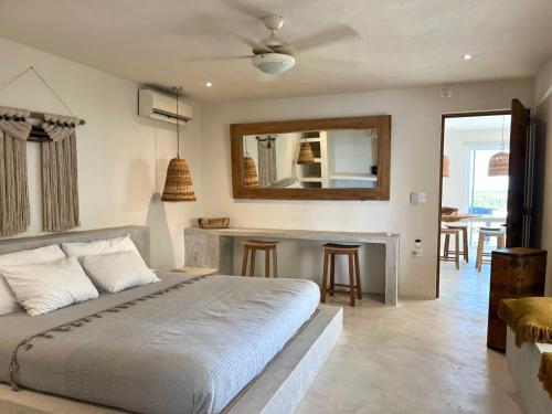 a bedroom with a large bed and a dining room at Casa en primera linea de playa con alberca in Sisal