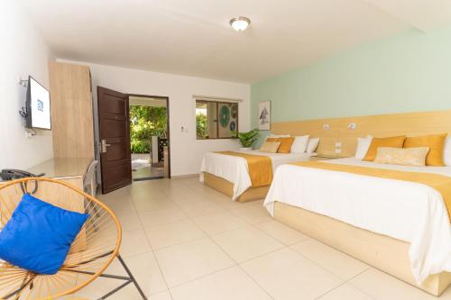 una camera d'albergo con due letti e una sedia di Hotel Los Farallones a La Libertad