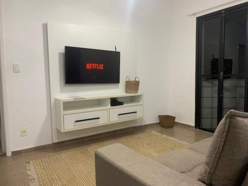 Uma televisão e/ou sistema de entretenimento em Lindo Apartamento Vista mar Portaria 24h Piscina e Lazer