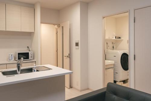 uma cozinha com um lavatório e um micro-ondas em 谷町君ホテル　難波80 em Osaka