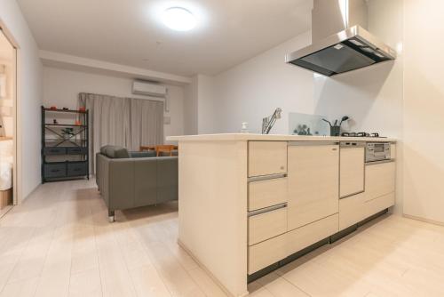 a kitchen with a counter and a couch in a room at 谷町君ホテル　難波80 in Osaka