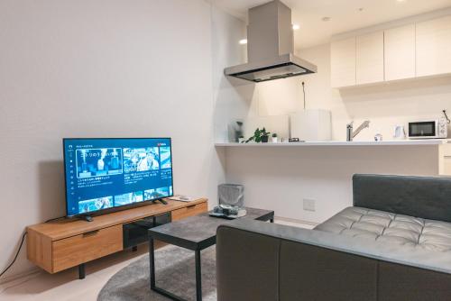 a living room with a couch and a flat screen tv at 谷町君ホテル　難波80 in Osaka