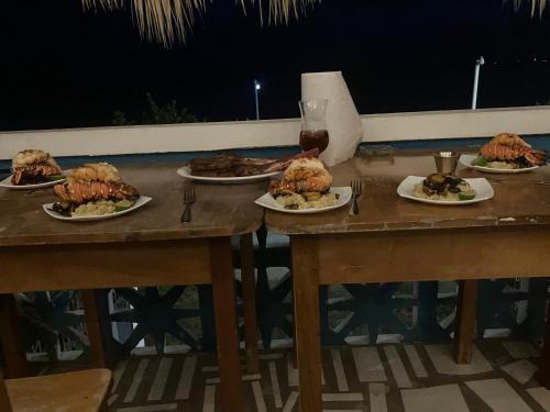 a table with plates of food and a glass of wine at Rum punch lodge in Corozal