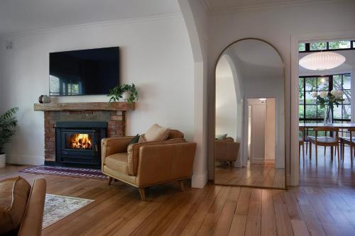 a living room with a couch and a fireplace at Stanbridge House- perfect escape, modern comforts in Daylesford