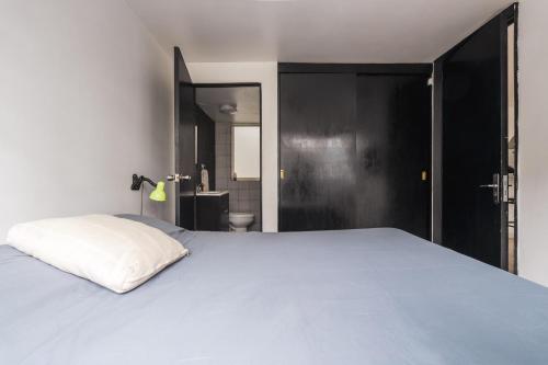 1 Schlafzimmer mit einem weißen Bett und einem Badezimmer in der Unterkunft nice apt. Roma CDMX :) in Mexiko-Stadt