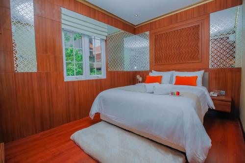 - une chambre avec un grand lit blanc et une fenêtre dans l'établissement PETIT BOUTIQUE HOTEL SOLO, à Solo