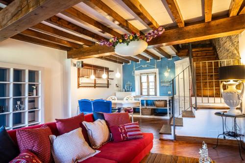 a living room with a red couch and a dining room at Il Borghetto in Agazzano