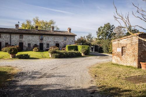 an old stone house with a gravel driveway at Il Borghetto in Agazzano