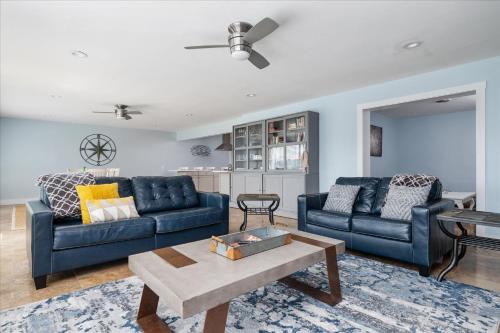 un soggiorno con 2 divani blu e un tavolo di Waterfront Bliss- Ultimate Tilghman Retreat home 