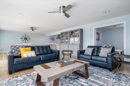 a living room with two blue couches and a table at Waterfront Bliss- Ultimate Tilghman Retreat home in Tilghman