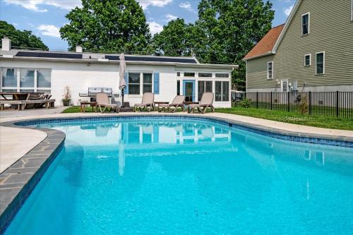a swimming pool in front of a house at Waterfront Bliss- Ultimate Tilghman Retreat home in Tilghman