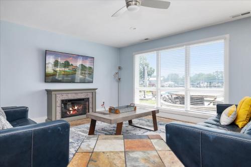 a living room with two blue couches and a fireplace at Waterfront Bliss- Ultimate Tilghman Retreat home in Tilghman
