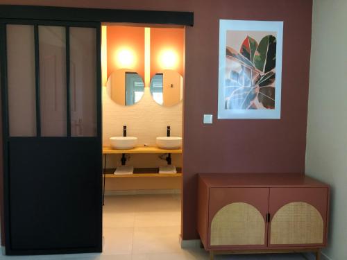 La salle de bains est pourvue de 2 lavabos et de 2 miroirs. dans l'établissement Villa Diamant Bleu, au Diamant