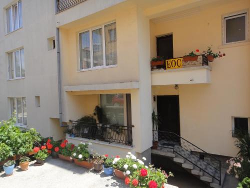 a building with potted plants and flowers in front of it at Guest house Eos in Sozopol