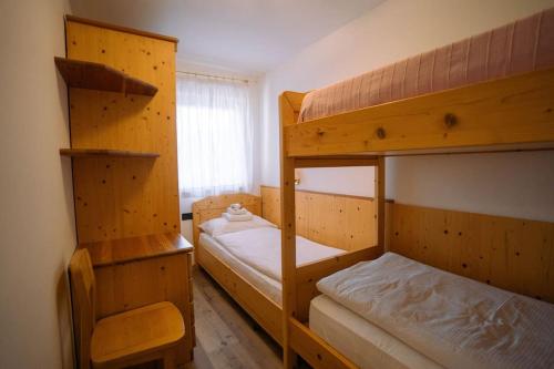 1 Schlafzimmer mit 2 Etagenbetten und einem Fenster in der Unterkunft Sun & Mountains Cavalese in Cavalese
