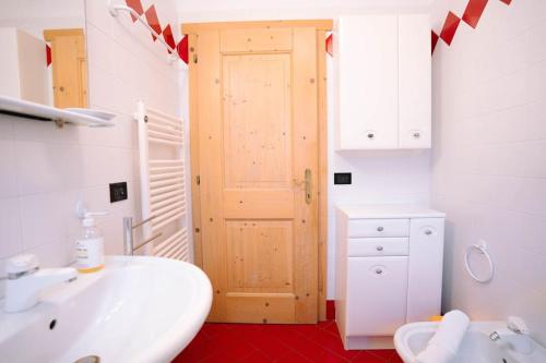 Sun & Mountains Cavalese في كافاليسي: حمام أبيض مع حوض ومرحاض