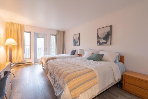 a bedroom with two beds and a flat screen tv at Big Sunshine in Mont-Tremblant