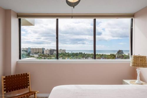 a bedroom with a window with a view of the ocean at Our House At The Beach, East Tower, 5th Fl in Siesta Key