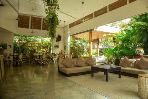 a living room with couches and a table and chairs at The White Palms of Nosara in Nosara