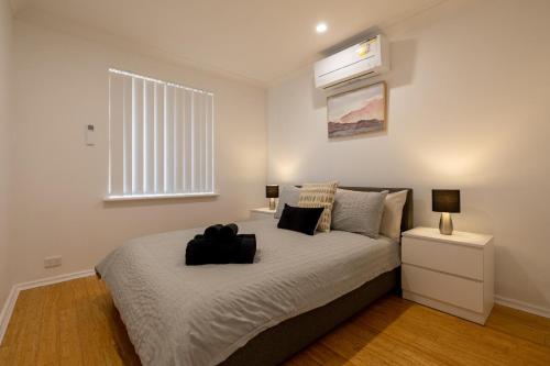 een slaapkamer met een bed met een zwarte tas erop bij 5 Swan Valley Special 3br 15 Bth - SUPERHOG VERIFICATION REQUIRED in Perth