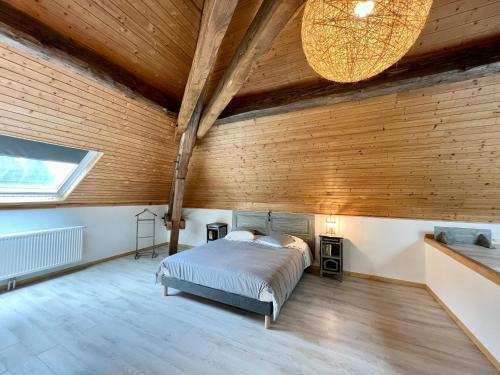 a bedroom with a bed and a wooden wall at Gîte Le Saulcy, 3 pièces, 4 personnes - FR-1-589-413 in Le Saulcy