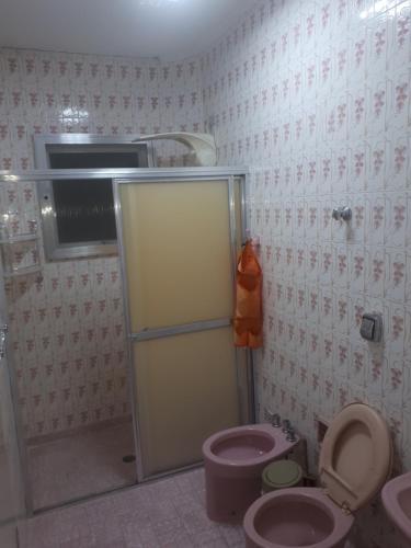 uma casa de banho com um chuveiro, um WC e um lavatório. em Alexandre Mayer em Peruíbe