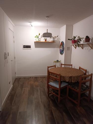 jadalnia ze stołem i krzesłami oraz pokój z białymi ścianami w obiekcie Departamento íntimo y de entorno natural. w mieście Temuco