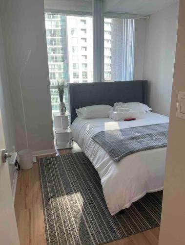 a bedroom with a large bed with a large window at 1BR Condo DWTN Toronto - free Parking, Gym & Pool in Toronto