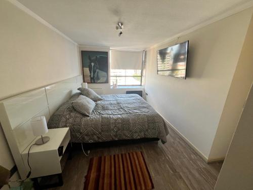 a small bedroom with a bed and a window at City House Andes Bello in Temuco