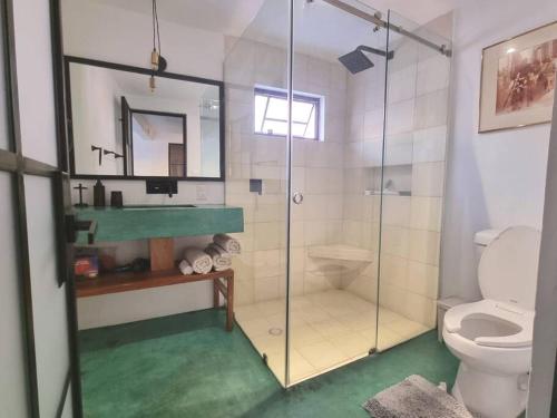 a bathroom with a glass shower and a toilet at El Andador House Downtown with Free Parking And Aire AC in San Miguel de Allende