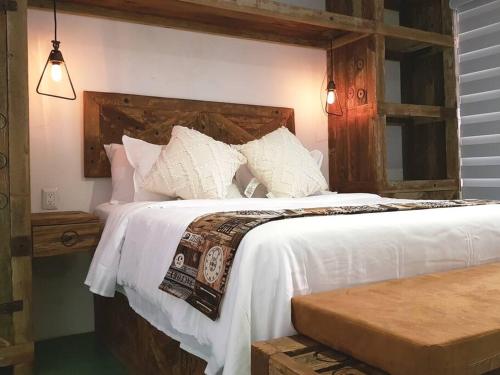 a bedroom with a large bed with white sheets and pillows at El Andador House Downtown with Free Parking And Aire AC in San Miguel de Allende