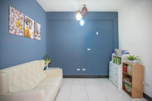 a living room with a white couch and a blue wall at 卡薩行旅壹館 包棟民宿 in Jinhu