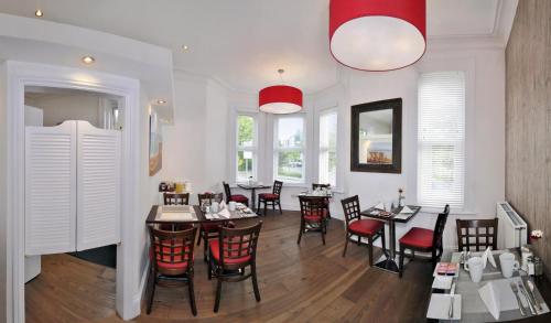 a dining room with tables and chairs and windows at Cavendish Central Bournemouth in Bournemouth